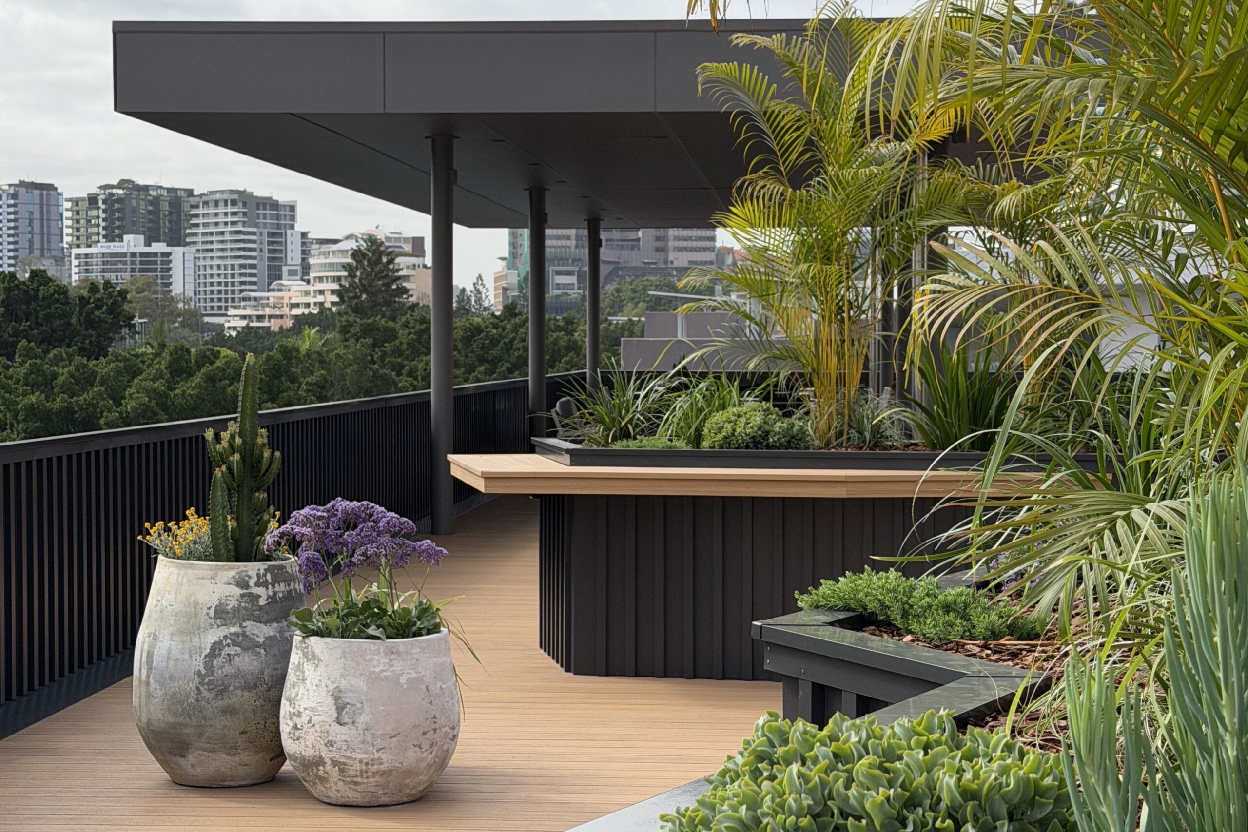 Rooftop terrace planted with palms, succulents and flowering sea lavender in weathered stone pots and built-in planters, overlooking a city skyline