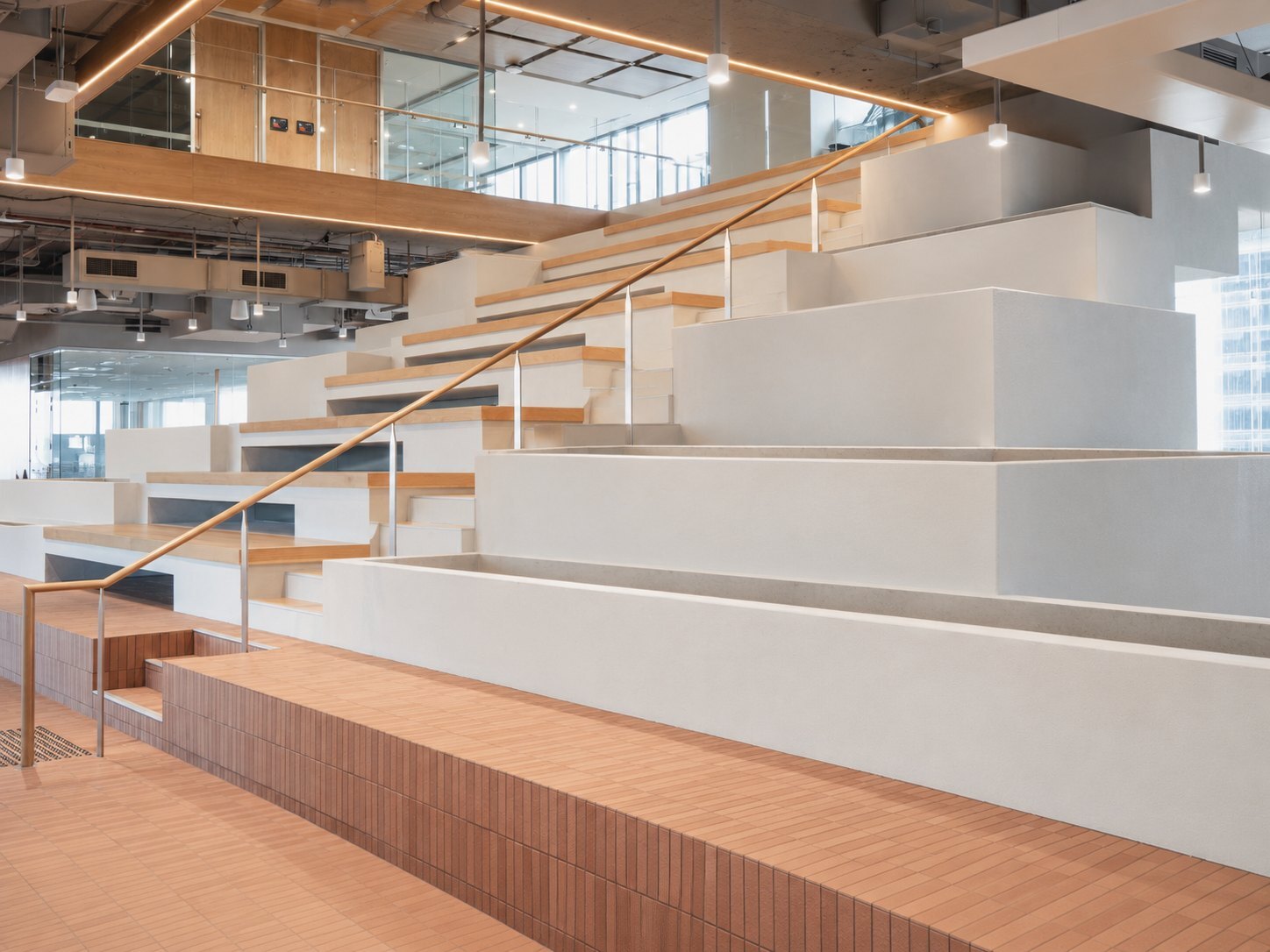 Empty tiered planters and timber stair seating in a Brisbane city office atrium, before indoor plant hire installation